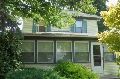 a house with large windows in a yard at Aunt Jane's Yellow House in Put-in-Bay