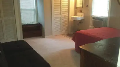 a bedroom with a bed and a sink in a room at Aunt Jane's Yellow House in Put-in-Bay