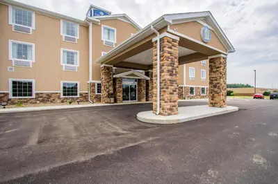 a building with a clock on the front of it at Cobblestone Hotel & Suites - Orrville in Orrville