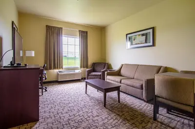a living room with a couch and a table at Cobblestone Hotel & Suites - Orrville in Orrville