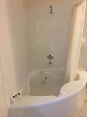 a white bath tub with a toilet in a bathroom at The North Star Inn in Corinth
