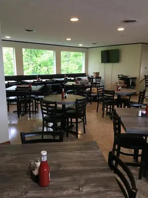 a restaurant with wooden tables and chairs and a room with tables and chairs at The North Star Inn in Corinth