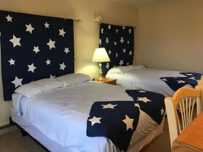 two beds in a room with stars on the wall at The North Star Inn in Corinth