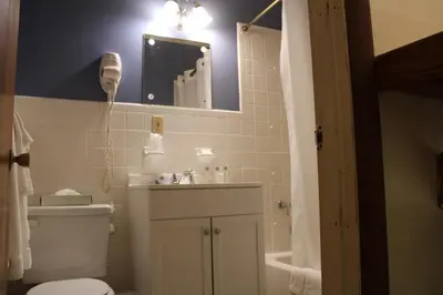a bathroom with a toilet and a sink and a mirror at The North Star Inn in Corinth