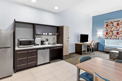 an open kitchen and dining room with a table and a room at Home2 Suites By Hilton Youngstown in Youngstown