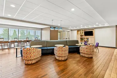 a lobby with a couch and tables and chairs at Home2 Suites By Hilton Youngstown in Youngstown