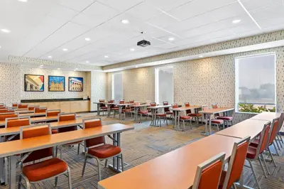 a dining room with tables and chairs and windows at Home2 Suites By Hilton Youngstown in Youngstown