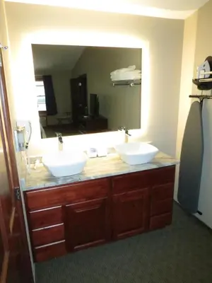 a bathroom with two sinks and a large mirror at Edgewater Hotel and Suites in Put-in-Bay