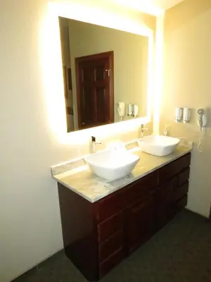 a bathroom with two sinks and a large mirror at Edgewater Hotel and Suites in Put-in-Bay