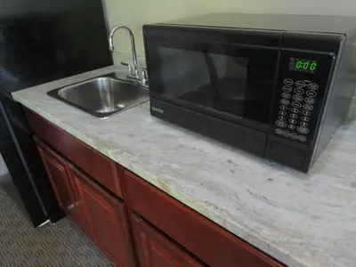 a microwave sitting on a counter next to a sink at Edgewater Hotel and Suites in Put-in-Bay