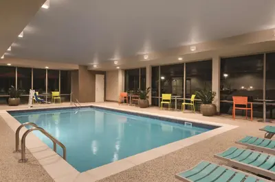 a pool in a hotel with chairs and tables at Home2 Suites By Hilton Columbus Dublin in Dublin