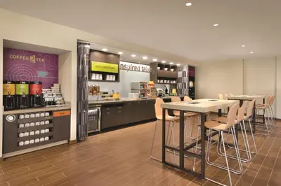 a restaurant with a counter and tables and chairs at Home2 Suites By Hilton Columbus Dublin in Dublin