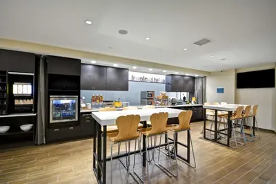 a kitchen with a table and chairs and a counter at Home2 Suites By Hilton Maumee Toledo in Maumee