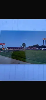 a view of a field of grass with a gas station at Deluxe Inn in Hebron