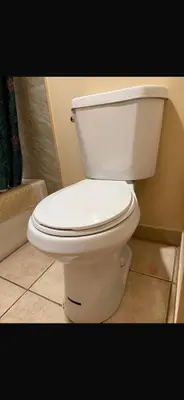 a white toilet sitting in a bathroom at Deluxe Inn in Hebron