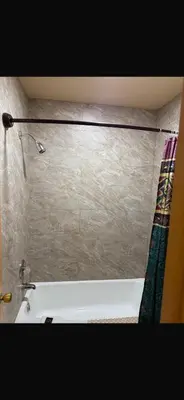a bathroom with a bath tub and a shower curtain at Deluxe Inn in Hebron
