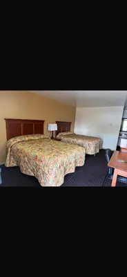 a hotel room with two beds and a table at Deluxe Inn in Hebron
