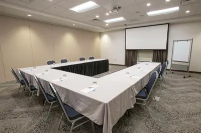 a conference room with a table and chairs and a screen at Hyatt Place Cincinnati/Sharonville Convention Center in Sharonville