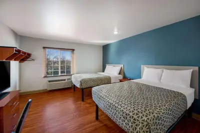 a hotel room with two beds and a window at WoodSpring Suites Columbus Southeast in Groveport