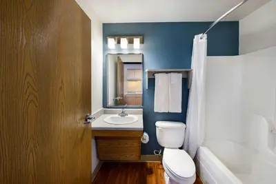 a bathroom with a toilet and a sink and a mirror at WoodSpring Suites Columbus Southeast in Groveport