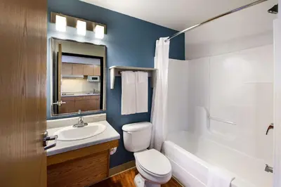 a bathroom with a white toilet and a sink at WoodSpring Suites Columbus Southeast in Groveport
