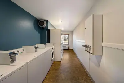 a laundry room with white appliances and a blue wall at WoodSpring Suites Columbus Southeast in Groveport