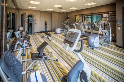 a gym with several treadmills and exercise bikes at Hilton Garden Inn Pittsburgh Airport in Moon Township