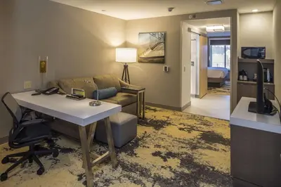 a living room with a couch and a desk in a room at Hilton Garden Inn Pittsburgh Airport in Moon Township