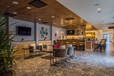 a lobby with tables and chairs and a bar at Hilton Garden Inn Pittsburgh Airport in Moon Township