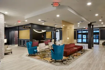 a lobby with a red couch and blue chairs at Hotel Indigo Cleveland Downtown by IHG in Cleveland
