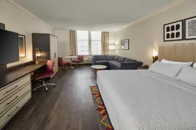 a hotel room with a bed and a living room at Hotel Indigo Cleveland Downtown by IHG in Cleveland