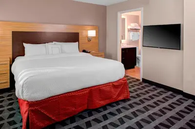 a bedroom with a large bed and a flat screen tv at TownePlace Suites by Marriott Parkersburg in Parkersburg