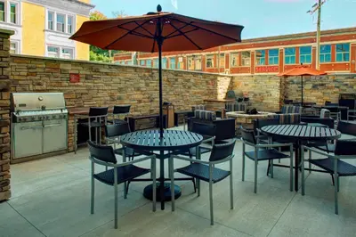 a patio with tables and chairs and an umbrella at TownePlace Suites by Marriott Parkersburg in Parkersburg