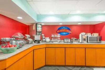 a fast food restaurant with a red wall at Baymont by Wyndham Greensburg in Greensburg