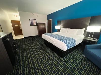 a hotel room with a bed and a blue wall at Baymont by Wyndham Greensburg in Greensburg