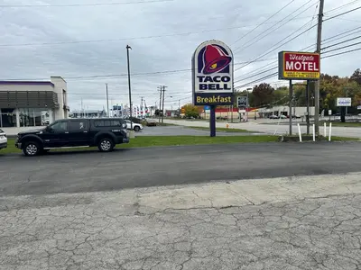 a car parked in a parking lot with a taco bell sign at Westgate Manor Motel Austintown & Youngstown OHIO in Youngstown