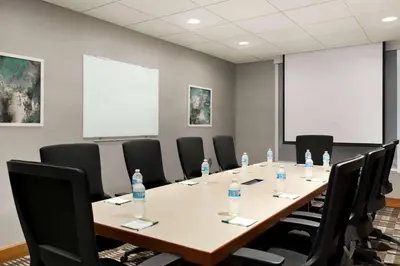a conference room with a table and chairs with water bottles at Wingate by Wyndham Cincinnati Blue Ash in Blue Ash