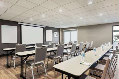 a conference room with tables and chairs in it at Wingate by Wyndham Cincinnati Blue Ash in Blue Ash