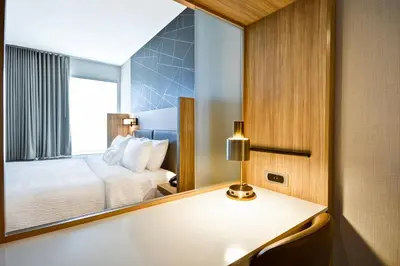 a hotel room with a bed and a mirror at SpringHill Suites by Marriott Cincinnati Blue Ash in Blue Ash