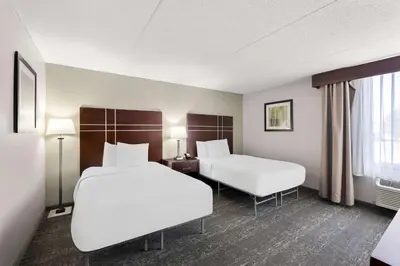a hotel room with two beds and a window at Best Western Luxbury Inn Fort Wayne in Fort Wayne