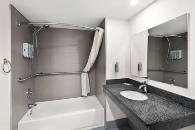 a bathroom with a sink and a bath tub at Best Western Luxbury Inn Fort Wayne in Fort Wayne