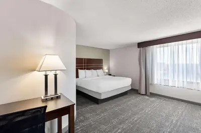 a hotel room with a bed and a window at Best Western Luxbury Inn Fort Wayne in Fort Wayne