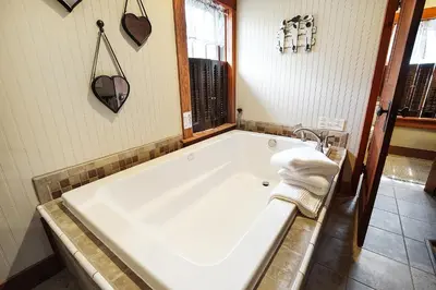 a bathroom with a large white tub in a room at Hocking Hills Inn in Logan