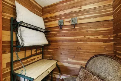 a room with wooden walls and a bunk bed and a chair at Hocking Hills Inn in Logan