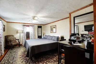 a bedroom with a bed and a desk and a chair at Hocking Hills Inn in Logan