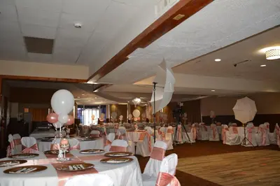 a banquet hall with white tables and chairs and balloons at Columbus Grand Hotel & Banquet Center in Columbus