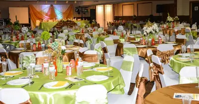 a banquet hall with green tables and chairs at Columbus Grand Hotel & Banquet Center in Columbus