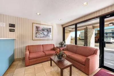 a living room with two couches and a table at Rodeway Inn Columbus West in Columbus