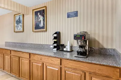 a kitchen with a counter with a coffee maker on it at Rodeway Inn Columbus West in Columbus