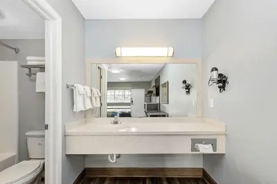 a bathroom with a sink and a mirror at Grove City Travel Inn South Columbus in Grove City